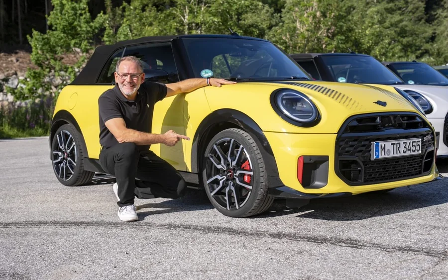 Christian Karg, responsable de la dynamique de conduite chez BMW Group, posant à côté d’une MINI jaune