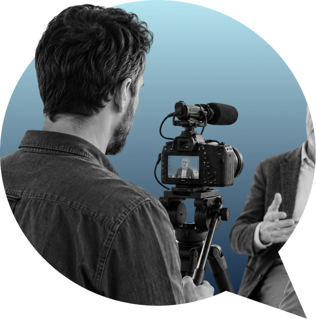 Cadreur filmant une interview au reflex sur trépied, micro monté sur la caméra